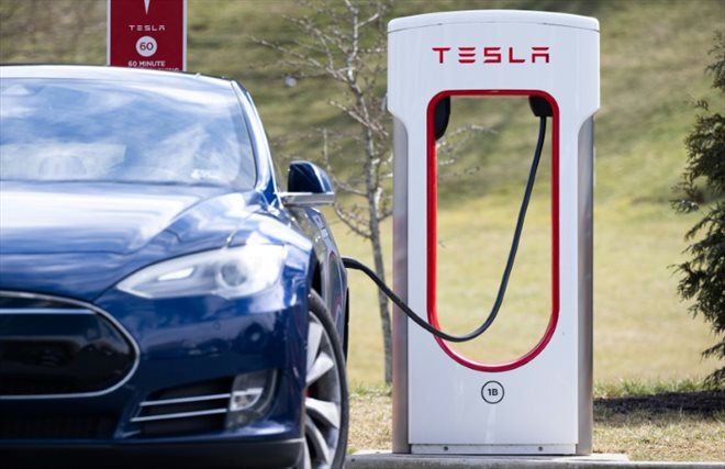 Une voiture électrique branchée à un Superchargeur Tesla, le 13 février 2023 à Falls Church, en Virginie