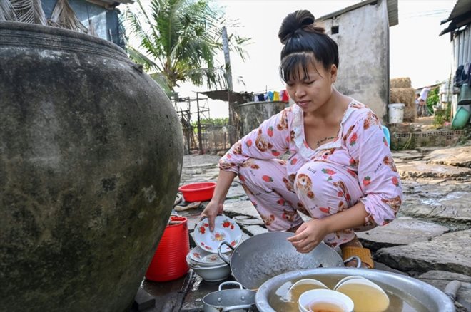 L'agricultrice Nguyen Hoai Thuong fait la vaisselle chez elle, dans la province de Ben Tre, le 19 mars 2024 dans le sud du Vietnam